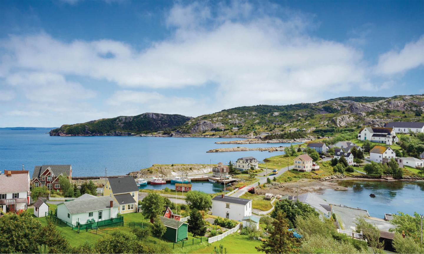 A colorful coastal town with bright houses nestled around a calm blue body of water.